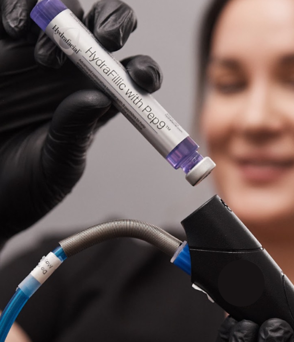 A provider holds a personalized Hydrafacial booster serum